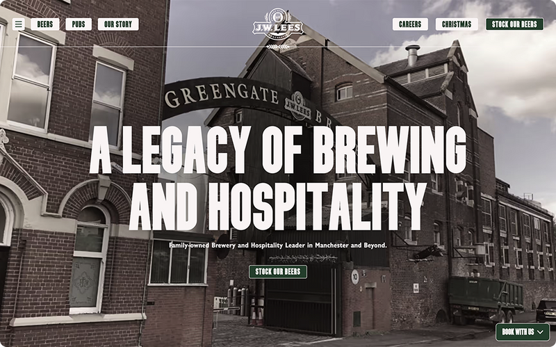A brewery, showcasing its history, is situated in a brick industrial area. "A LEGACY OF BREWING AND HOSPITALITY. Family-owned Brewery and Hospitality Leader in Manchester and Beyond.